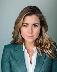 a woman in a green blazer posing for a photo